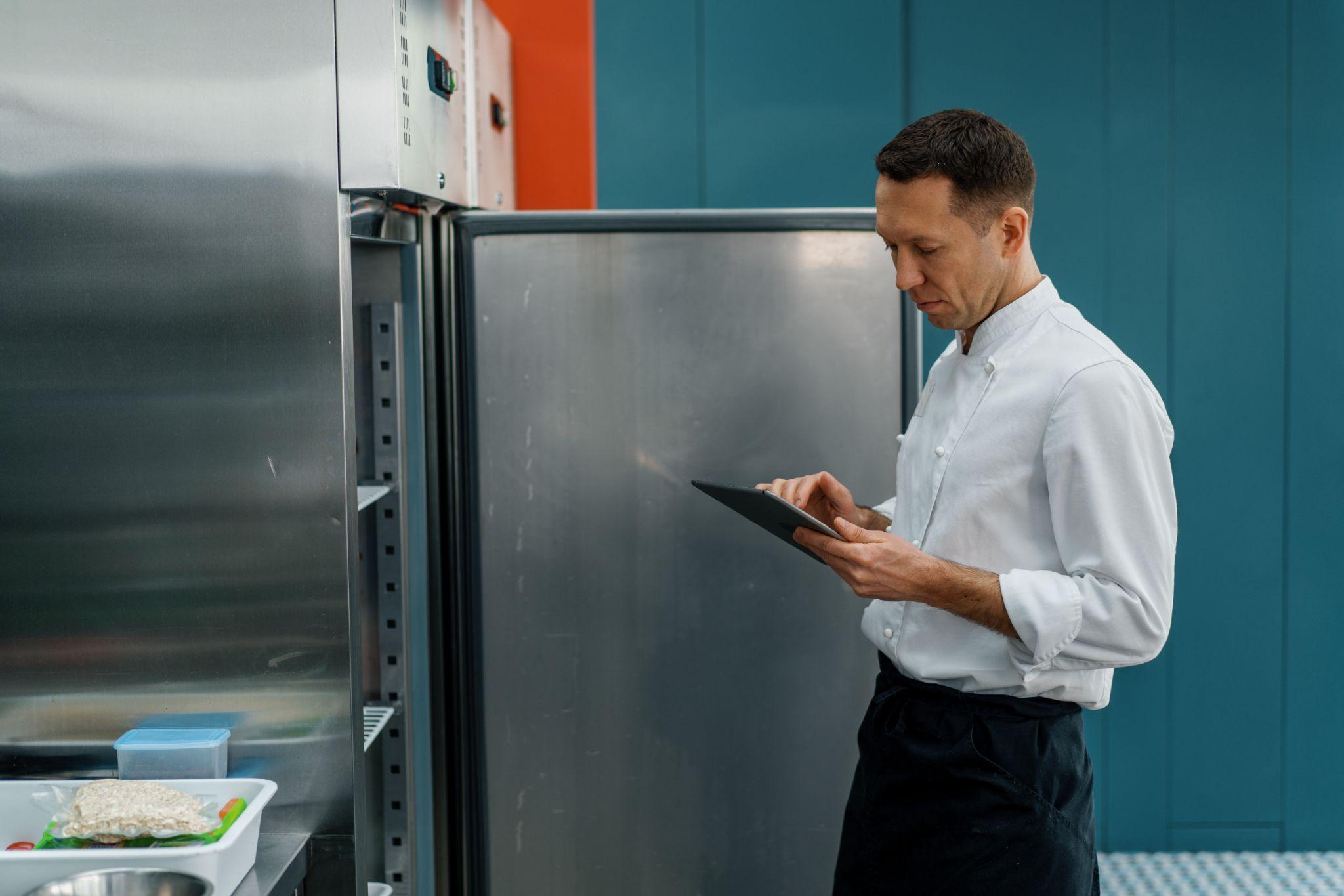 professional-chef-using-tablet-computer-for-recipes-while-working-in-modern-kitchen-cooking-concept