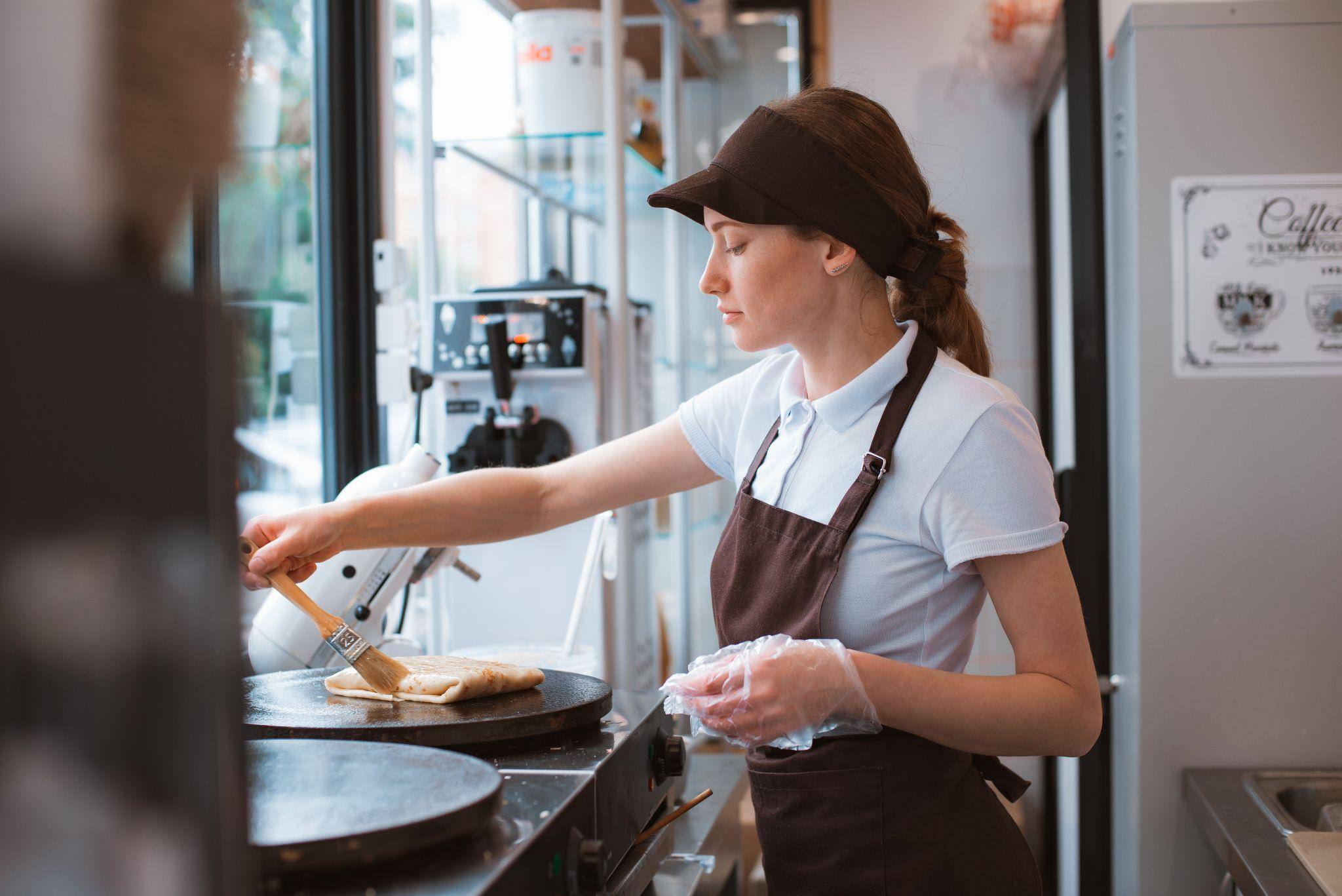 woman-chef-baking-pancakes-in-an-apron-uniform